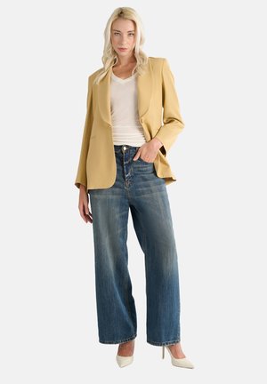 Light yellow blazer over a white top, paired with high-waisted, wide-leg blue jeans and cream high heels. Minimalistic design and textures.