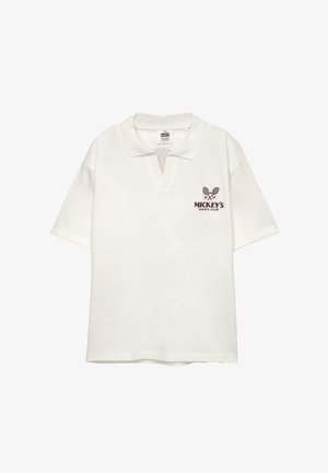 Fehér póló rövid ujjakkal, gallérral és V dekoltázzsal. Jellemzi egy barna nyomott logó, amely keresztezett teniszütőket és a "Mickey's Tennis Club" feliratot tartalmaz.