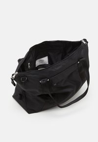 Sac fourre-tout noir avec un intérieur spacieux, deux zips sur le dessus et des poignées en tissu. À l'intérieur, on trouve une poche zippée et une étiquette avec des informations sur la marque.