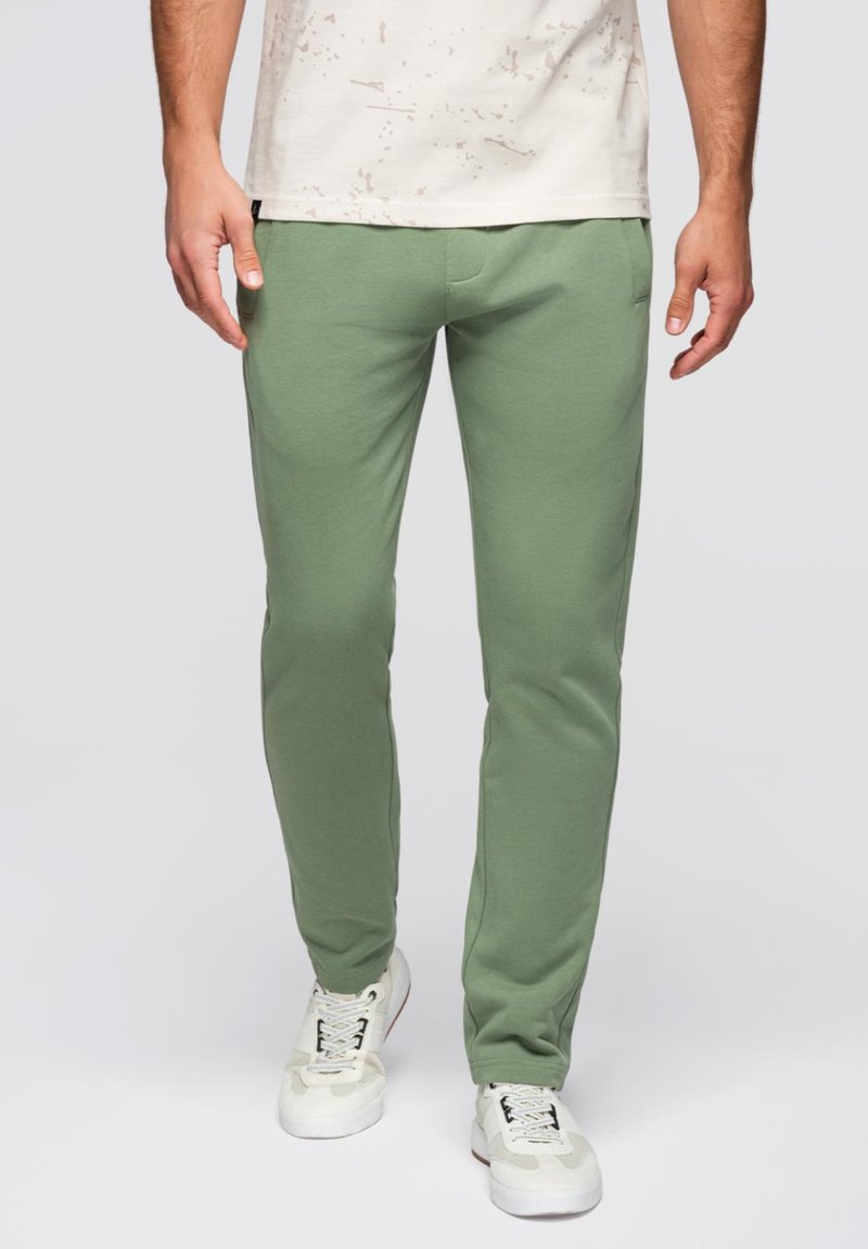 Groene katoenen joggingbroek met een slim fit, voorzien van zijzakken en een gladde textuur. Draag het met witte sneakers voor een casual uitstraling.