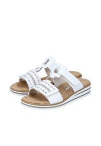 Witte sandalen met twee verstelbare banden, een gevoerde tan binnenzool en een wit en grijs gestreepte buitenzool; voorzien van kleine decoratieve uitsparingen.