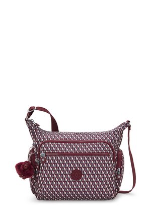 Sac bandoulière avec motif géométrique bordeaux, plusieurs poches zippées, bandoulière réglable et accessoire porte-clés en pompon bordeaux.