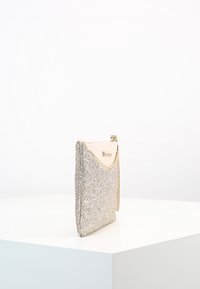 Glittrande silver clutch med en texturerad glittrig yta, ljusbeige överdel och en minimalistisk design. Har en dragkedjestängning.