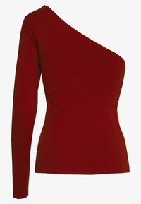 Červený žebrovaný top s asymetrickým výstřihem, jedním dlouhým rukávem a přiléhavým střihem. Hladká textura, elastický materiál.