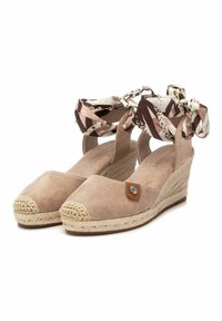 Scarpe con zeppa in suede beige, con suola in juta, caratterizzate da punta tondeggiante e lacci in tessuto decorato alla caviglia. Dettaglio in pelle con logo metallico.