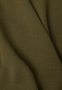 Gros plan sur un tissu tricoté vert olive doux montrant une fine texture côtelée et des plis délicats.