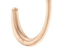 Orecchino metallico curvo in oro rosa con una finitura lucida, caratterizzato da una sottile incisione "CK" vicino alla base. Texture liscia.