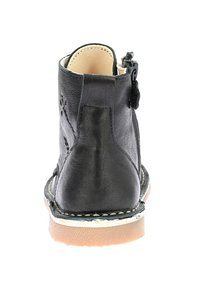 Stivale alla caviglia in pelle nera con chiusura a zip, retro testurizzato, fodera beige e suola in gomma a contrasto con cuciture bianche.