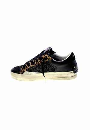 Zapatilla de cuero negro con acentos de estampado de leopardo, lado texturizado y suela de goma beige. Presenta un diseño de cordones y detalles metálicos.