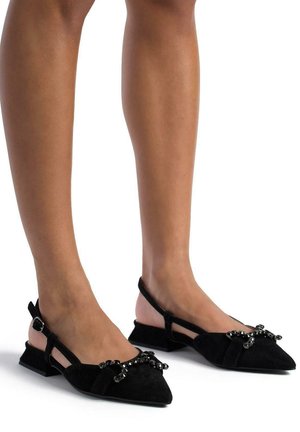 Chaussures plates slingback en suède noir avec un bout pointu et un petit talon bloc. Dotées d'accents décoratifs en perles sur le devant et d'une sangle ajustable.
