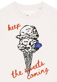 Weißes T-Shirt mit einer schwarzen Kontur eines Eisbechers, der zwei Kugeln zeigt. Roter Text sagt "lass die Süßigkeiten kommen", und ein blauer Aufkleber trägt die Aufschrift "Eiscreme".