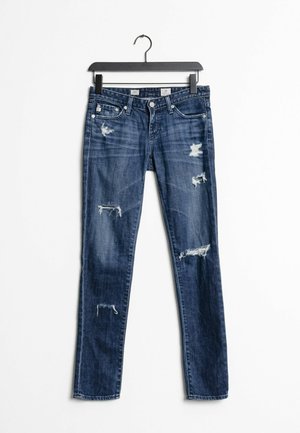 Smala jeans i mörkblå denim med slitna lappar och fransade kanter. Har fem fickor och en vanlig midja med knappstängning.