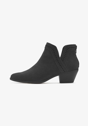 Black ankle boots made of suede, featuring a pointed toe, cut-out designs along the sides, and a small stacked heel.