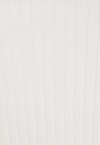Bílá žebrovaná pletenina se svislými liniemi. Měkká textura s hladkým povrchem a jemným leskem po celém materiálu.