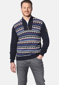 Marineblaue Strickjacke mit Reißverschluss-Kragen, die ein geometrisches Muster in Blau, Rot und Grau aufweist. Rippbündchen und -saum. Glatte Stricktextur.