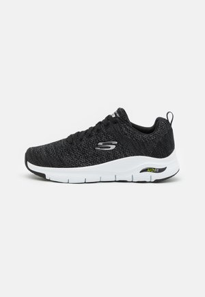 Czarne sportowe buty z siateczki z białą podeszwą i teksturowanym wzorem. Posiadają sznurówki oraz oznaczenie "ArchFit" po boku dla lepszego wsparcia.