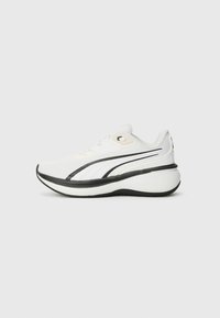 White athletic shoe with a textured mesh upper, black accent stripes, rounded sole, and lace-up design for a secure fit.