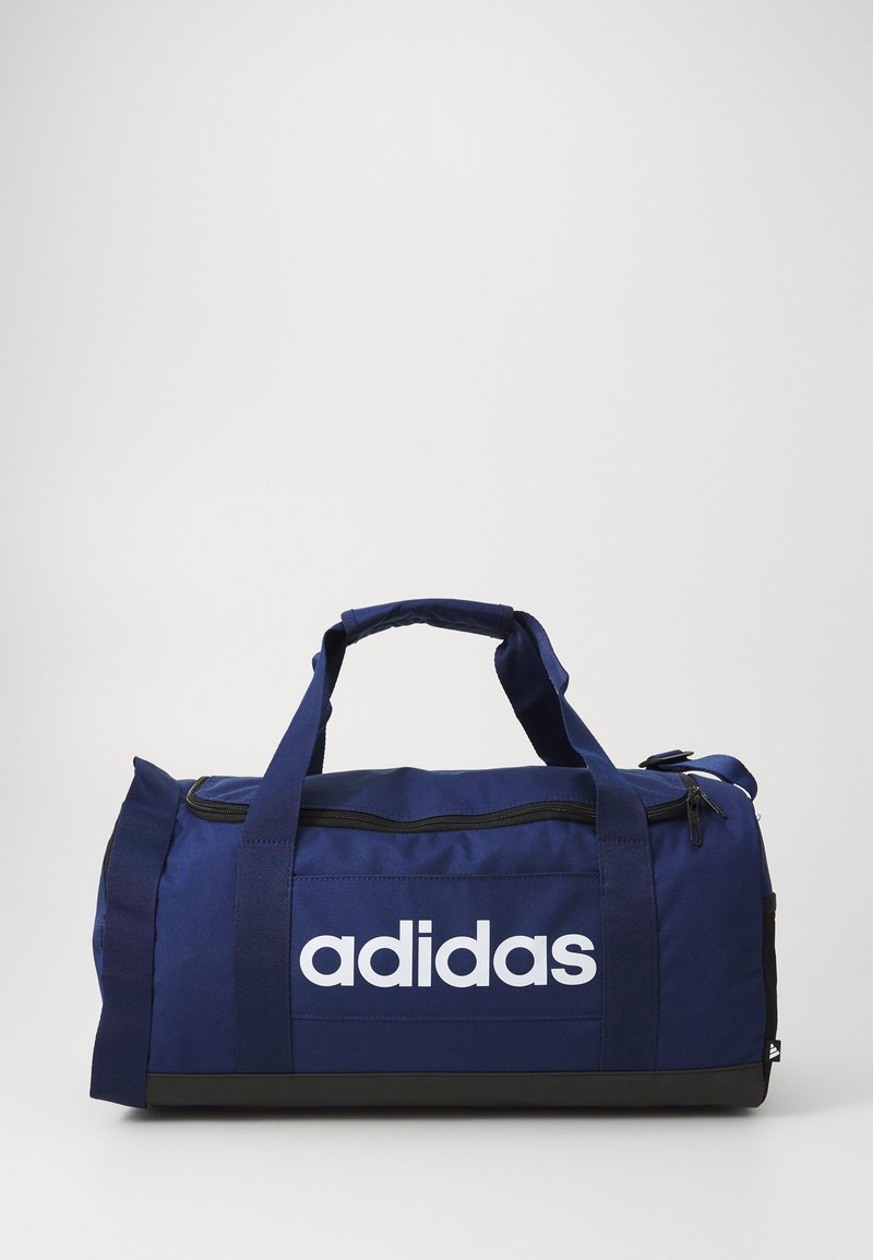 Navy blue duffel bag with white "adidas" logo, fabric material, cylindrical shape, dual carrying handles, and a zippered top closure.