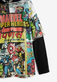 Lyhythihainen t-paita, jossa on värikäs sarjakuvaprintti Marvel-suosikkisankareista, pääasiassa mustissa, keltaisissa ja punaisissa väreissä.