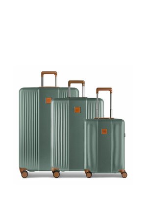 Trois valises rigides vertes avec des poignées marron et quatre roues, disposées de la plus grande à la plus petite sur un fond blanc.
