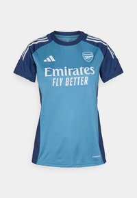Turkos och marinblå fotbollströja med korta ärmar, med en vit "Emirates" logotyp, texten "FLY BETTER" och Adidas-stripes.