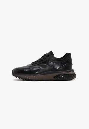 Zapatillas de cuero negro con un diseño elegante, partes superiores texturizadas, acentos perforados y una suela de goma con un patrón distintivo.