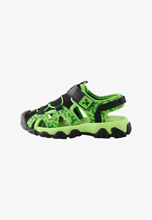 Sandale d'extérieur pour enfants à bout fermé en vert et noir avec un motif pixélisé, bride en velcro ajustable et semelle robuste.