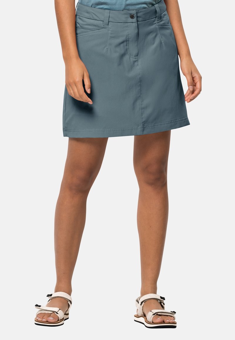 Sukně do půli kolen v odstínu modrozelené vyrobená z lehkého materiálu má zapínání na knoflík, boční kapsy a přímý spodní lem.