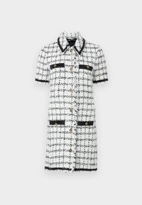 White and black checkered dress made of textured fabric, featuring short sleeves, gold buttons, and black accents on pockets and collar.