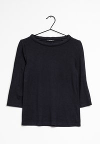 Top negro de manga larga con cuello redondo y una textura suave, colgado de un gancho negro sobre un fondo blanco.