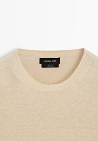 Beige linnen trui met ronde hals en geribbelde kraag, voorzien van een zwart Massimo Dutti-label aan de binnenkant van de halslijn.