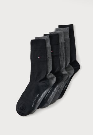Cinq paires de chaussettes montantes noires et grises avec petits logos Tommy Hilfiger et motifs de tricot variés, disposées côte à côte sur un fond blanc.
