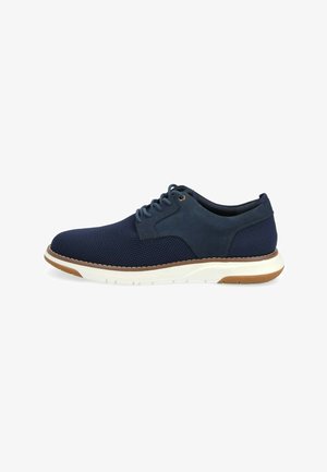 Scarpa laceless in rete e suede blu navy con suola intermedia bianca e suola in gomma marrone; presenta una punta arrotondata e dettagli perforati.