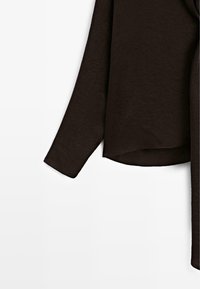 T-shirt marron à manches longues en tissu texturé. Il présente une coupe décontractée, un ourlet légèrement incurvé et un design simple sans embellissements.