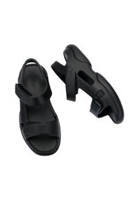 Sandali neri con una tomaia testurizzata, due cinturini regolabili e una soletta imbottita. Design leggero con dettagli a taglio per la traspirabilità.