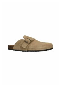 Chaussure beige en suède à enfiler avec une semelle en caoutchouc plate, dotée d'une seule sangle ajustable et d'une semelle intérieure en liège pour le confort.