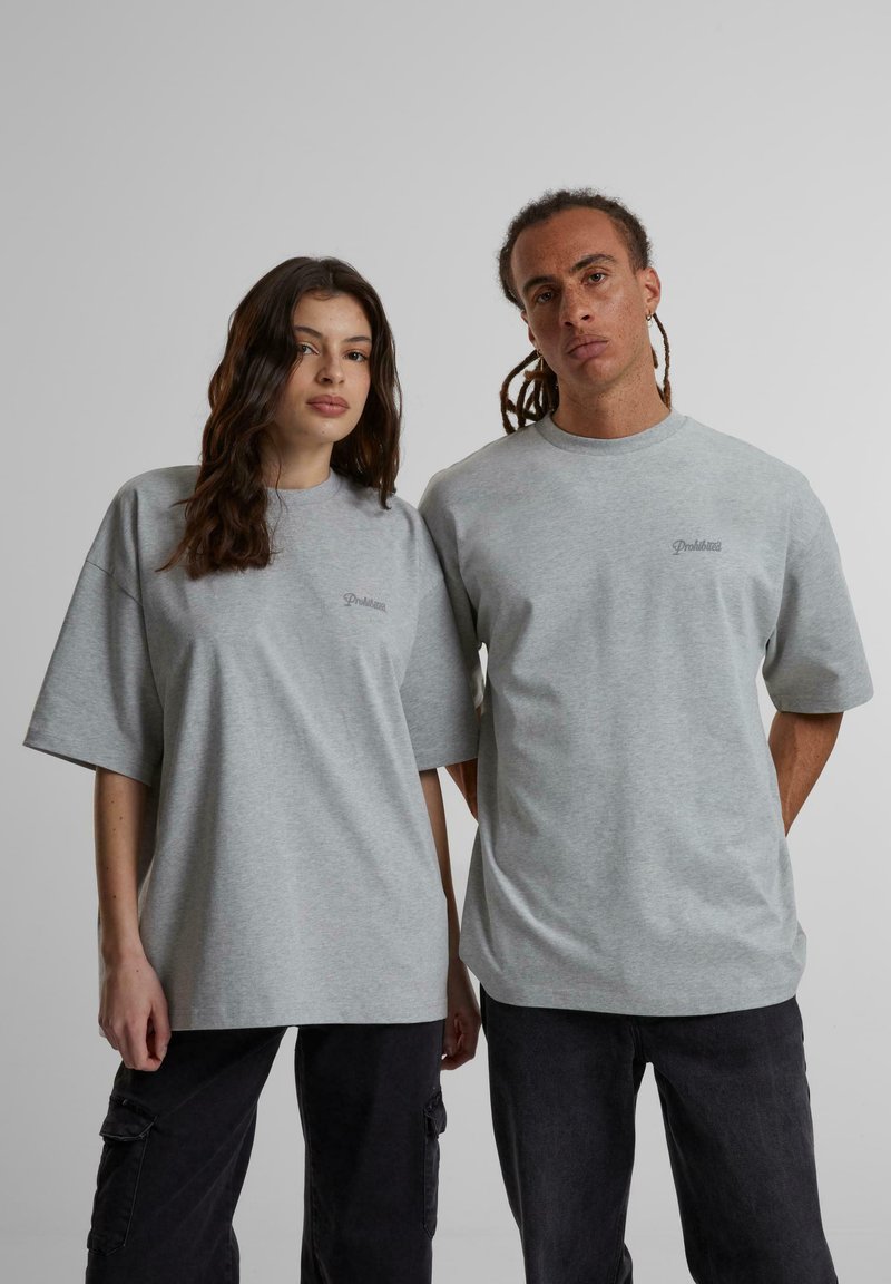 Grå oversized t-skjorter laget av myk bomullsblandingsstoff, med korte ermer og en enkel logo detalj i lys broderi.