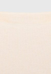 Tissu beige clair côtelé avec une texture douce. Présente des lignes horizontales discrètes et un col lisse, adapté à un style polyvalent.