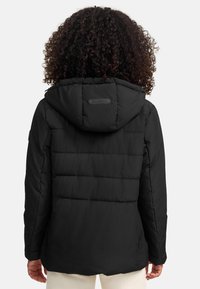 Černá prošívaná bunda s kapucí, s prošívaným designem, texturovanou tkaninou a značkovým štítkem na horní části zad.