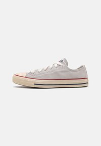 Sneakers de suede gri, cu șireturi albe, vârf rotunjit și talpă din cauciuc crem cu dungi accent roșii și albastre.