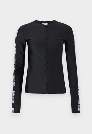 Veste noire à manches longues avec fermeture éclair, ornée de logos blancs Moschino courant le long des deux manches et d'un petit logo embossé sur la poitrine.