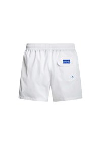 Bañador blanco con cintura elástica, bolsillo trasero con una etiqueta azul y una textura sutil. Diseño sencillo, adecuado para actividades acuáticas.