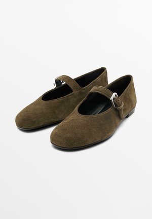 Chaussures Mary Jane en daim vert olive avec un bout arrondi, un accent de boucle latérale et un talon bas. Doublure intérieure lisse et semelle antidérapante.