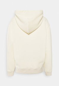 Mikina s kapucí v krémové barvě, vyrobená z měkké látky, s kapucí, žebrovanými manžetami a volným střihem. Minimalistický design bez viditelných log.