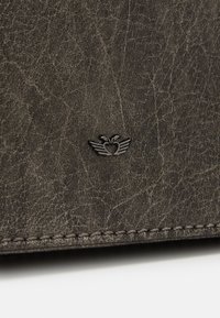 Czarnogranatowy skórzany portfel z teksturowaną powierzchnią, szytym brzegiem i małym wytłoczonym logo przypominającym skrzydła w rogu.