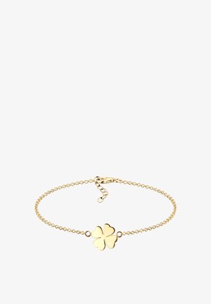 Auksinė grandinėlė su keturių lapų dobilo pakabuku, turinčiu lygius kraštus. Reguliuojama sagtis ir grandinės dizainas leidžia pritaikyti dydį.