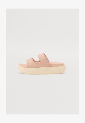 Infradito rosa chiaro con due cinturini regolabili, materiale morbido, suola larga e una suola esterna color crema a contrasto, con un logo del marchio discreto.
