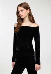 Top in velluto nero off-the-shoulder con maniche lunghe, caratterizzato da una texture liscia e elegante e una silhouette aderente.