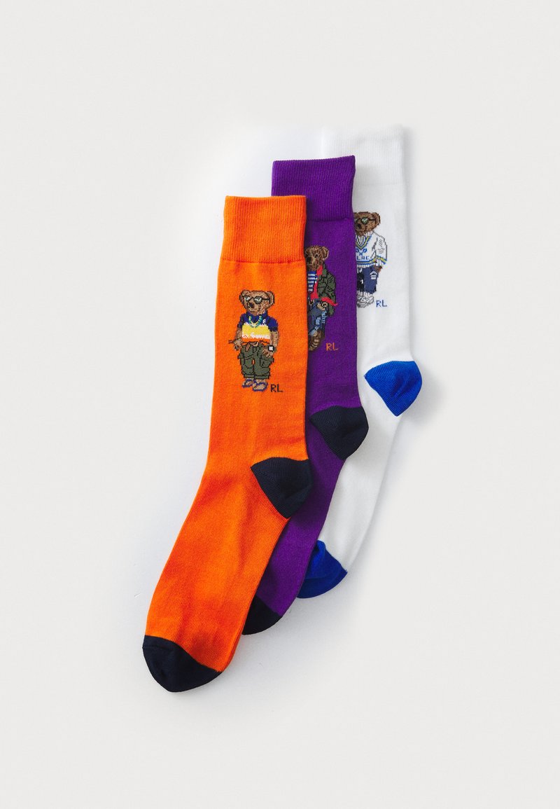 Three pairs of crew socks: bright orange, purple, and white, each with contrasting black toes. Each features a bear graphic in various outfits.