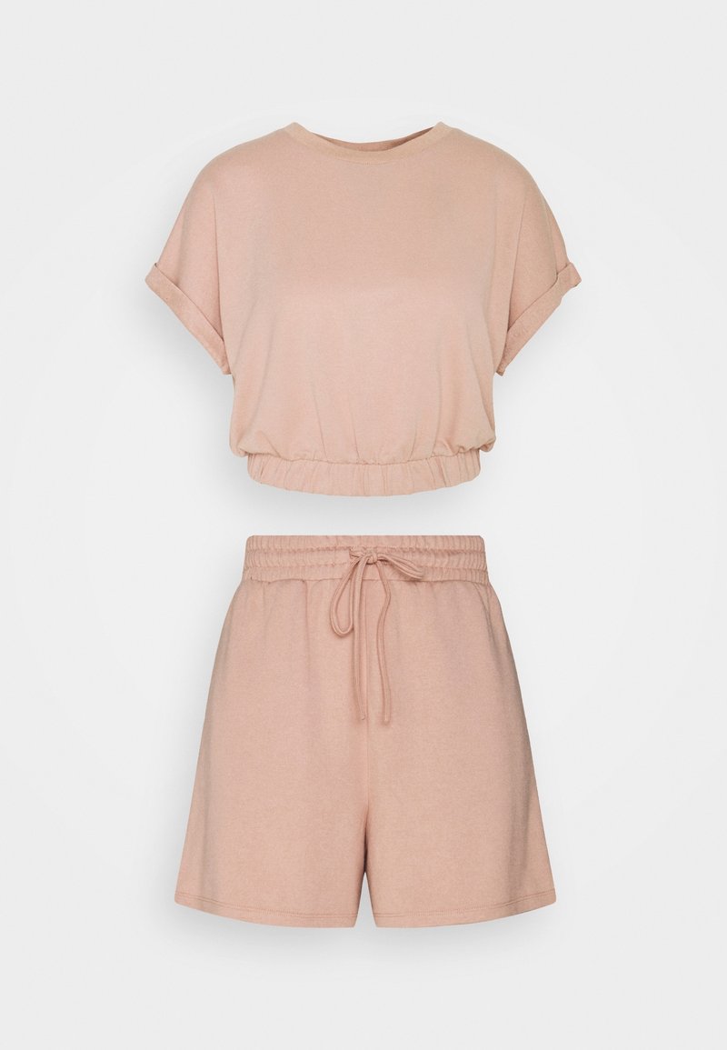 Ensemble deux pièces rose doux avec un haut court à manches courtes, revers roulés et ourlet élastique, associé à un short taille élastique avec cordon.